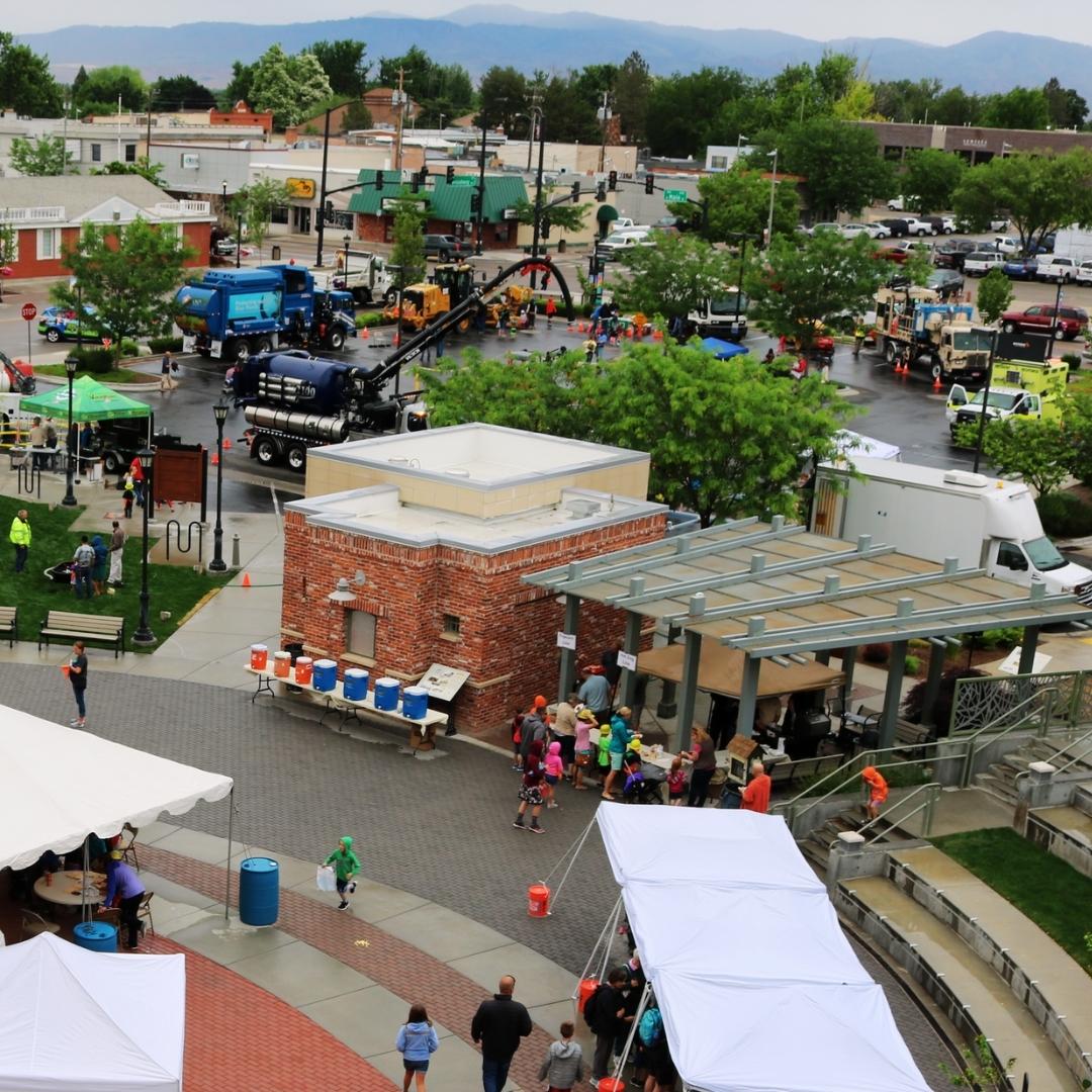 High up view of Public Works Week Expo. People, buildings, trash tucks, and other large equipment.